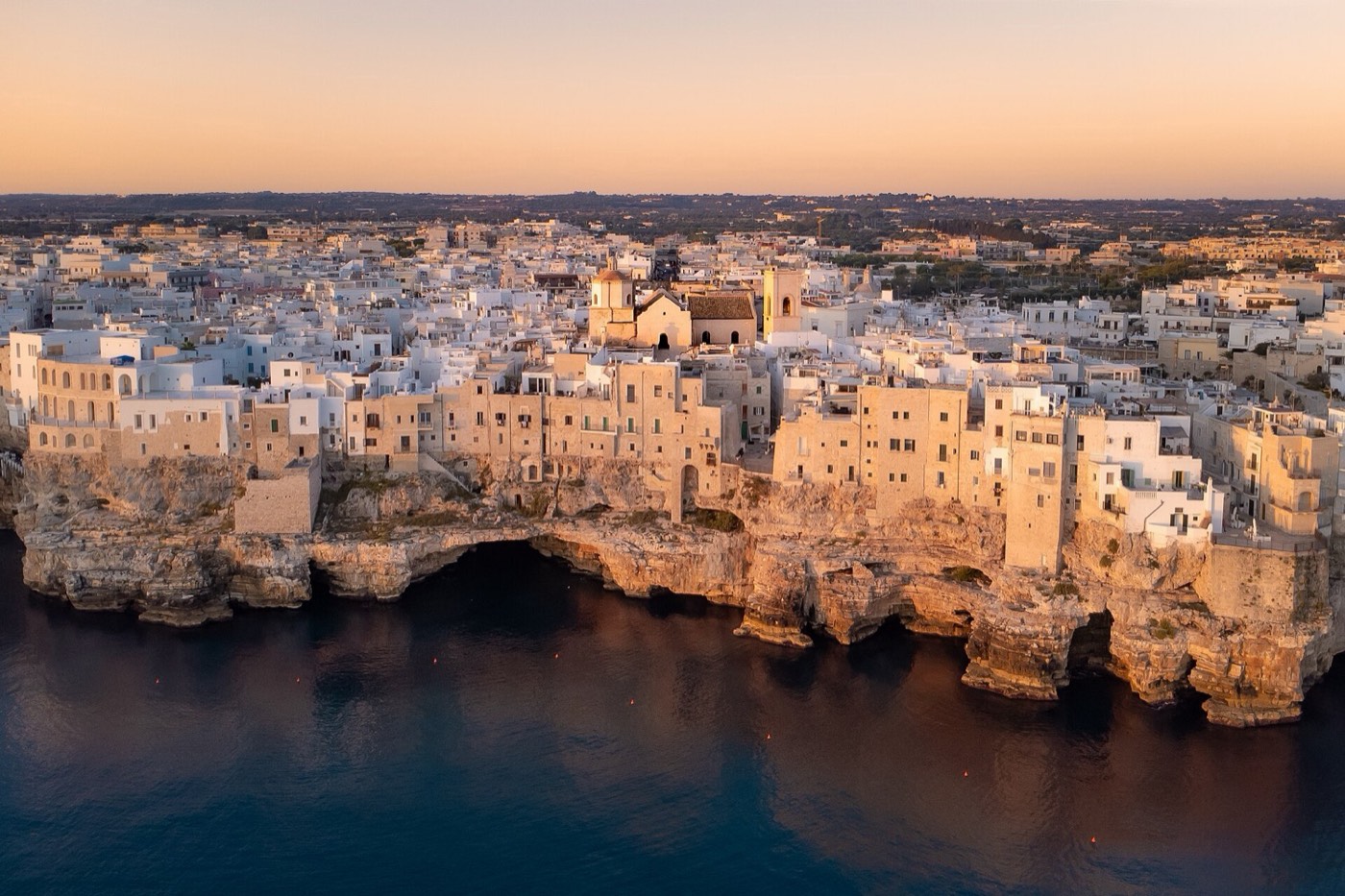 Polignano a Mare all'alba, con il centro storico a strapiombo sul mare